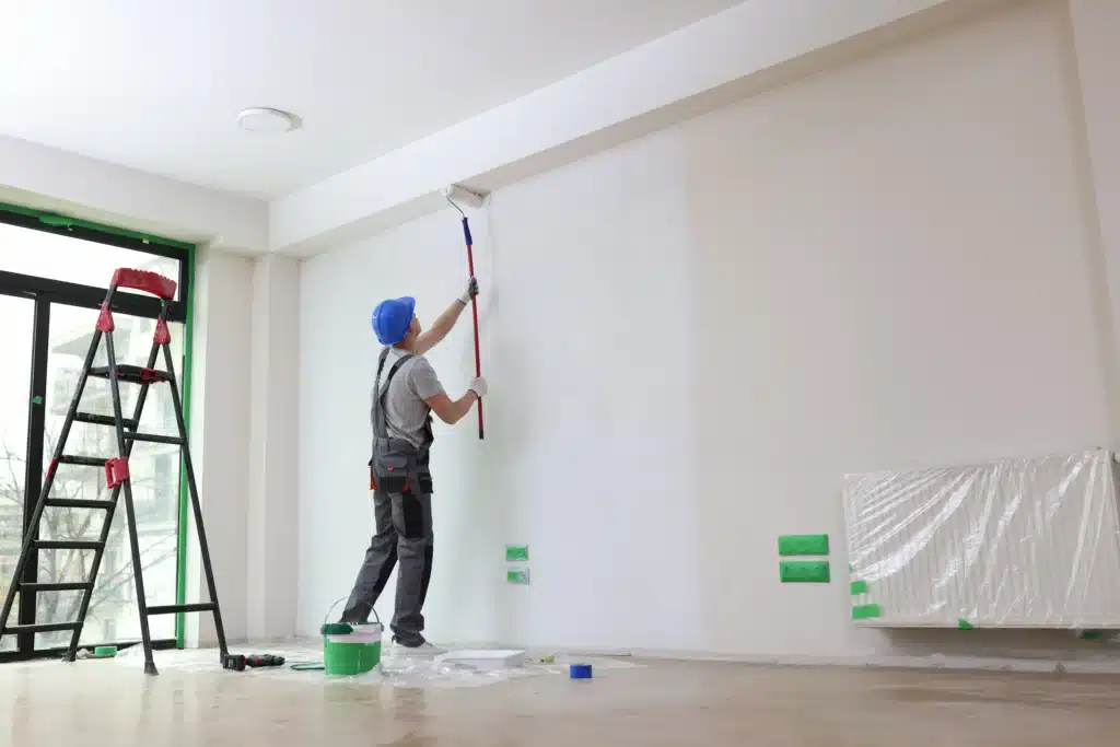 Homme effectuant la rénovation (peinture) d'un appartement